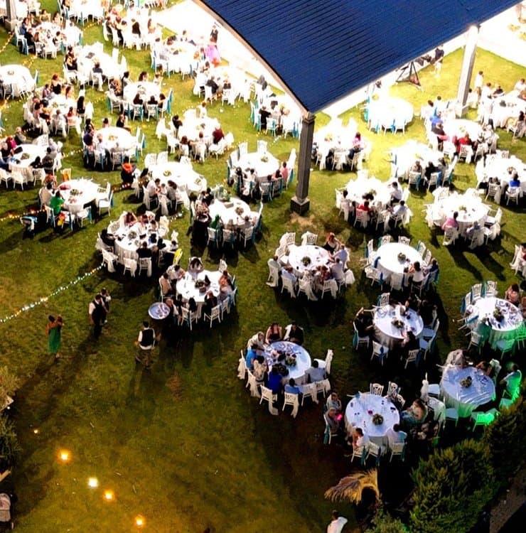 Çimenin üzerine kurulmuş yuvarlak yemek masaları