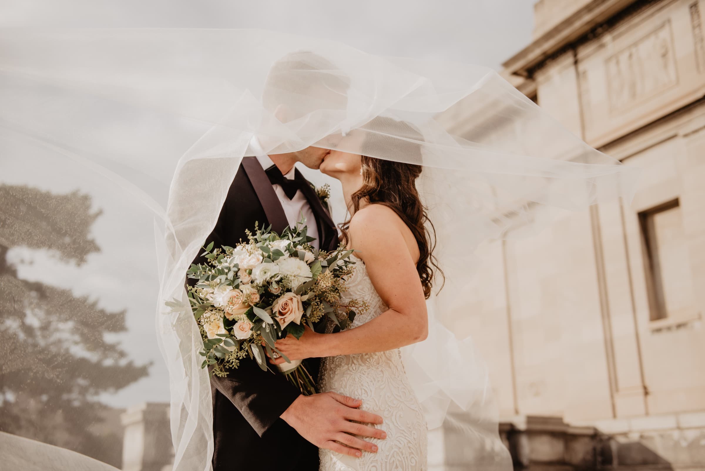 Duvağın altında öpüşen gelin ve damat